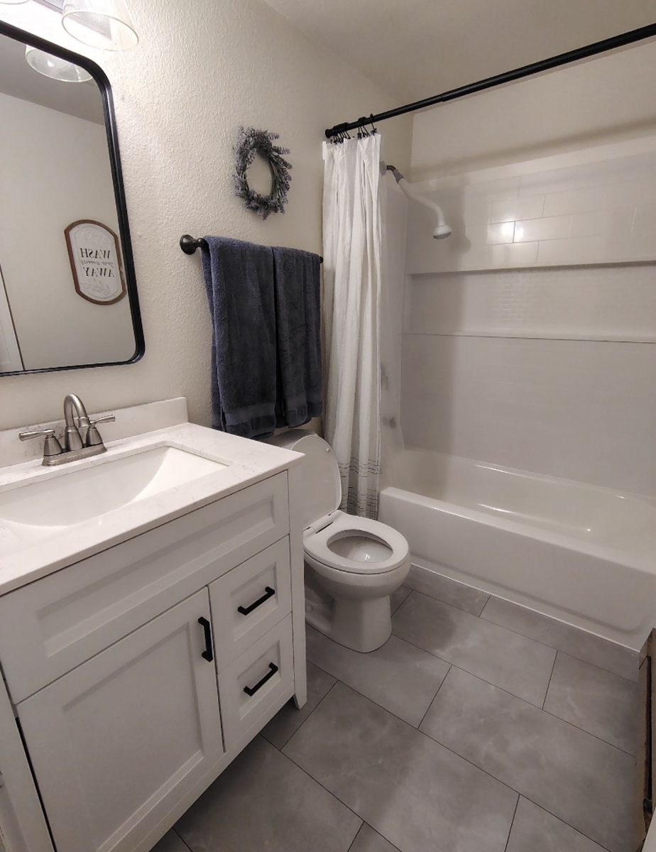 Finished bathroom with new tile floor, tub surround, vanity and fixtures
